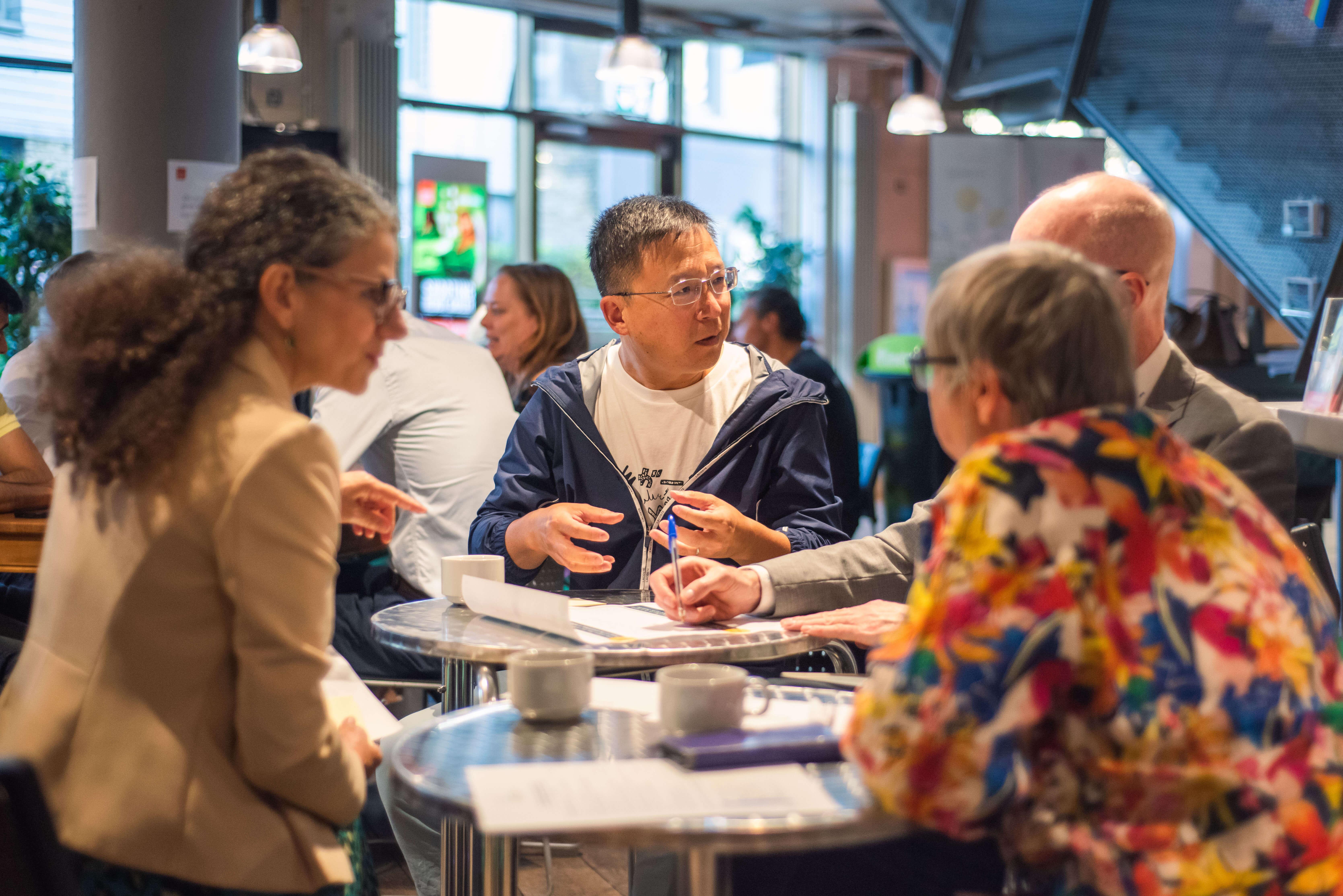 People sitting at round tables having coffee and chatting